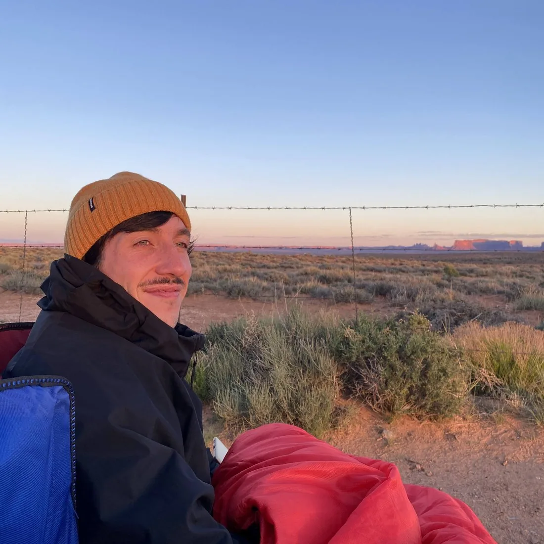 Julian at sunset in the Utah desert, Monument Valley on the horizon